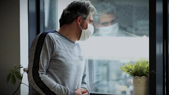 Man In A Medical Mask Watching Outside