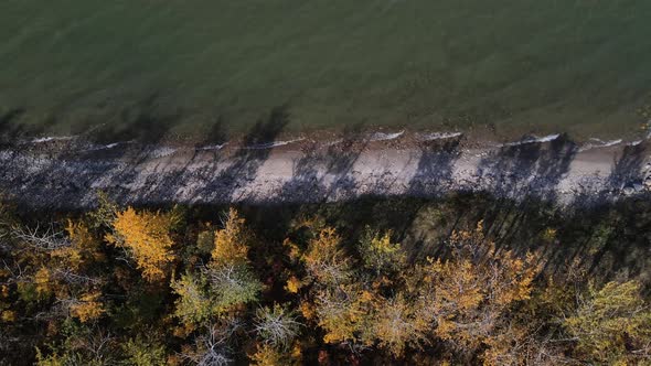 Top down aerial view of Buffalo lake's shoreline. Slowly forwarding droneement then gimbal up reveal