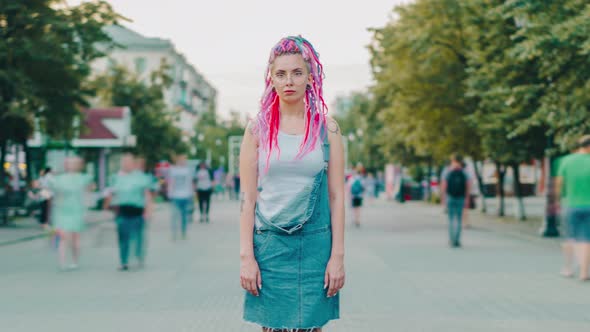 Time Lapse of Punk Girl with Dyed Hair and Tattoo Standing in Flow of People