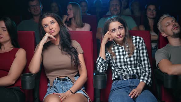 Two Female Spectators Watching Uninteresting Film Unpleasant Face Expression Sleeping Auditorium