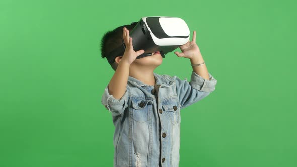 Little Boy In Virtual Reality Glasses. Green Screen