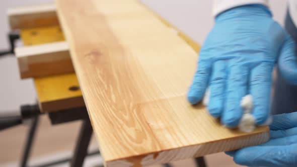 the Carpenter Rubs the Wood with Oil with a Napkin