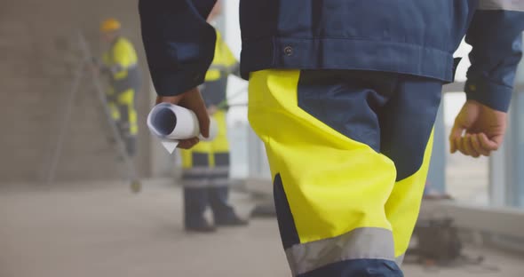 Cropped Shot of Engineer in Uniform with Blueprint at Construction Site