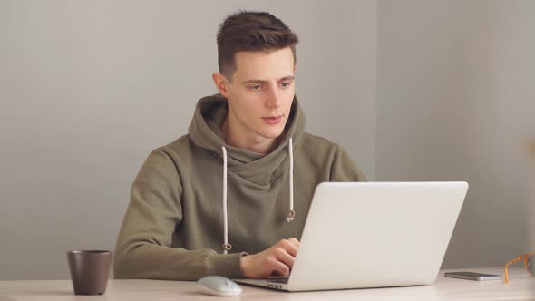 Modern Business Man Reading News on Laptop Computer in Office