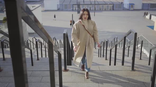 Portrait of Busy Caucasian Woman Running Up the Stairs in the City and Stopping for a Rest