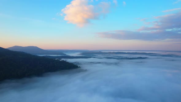 Aerial view of sunrise with fog above mountains