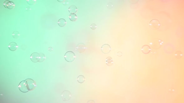 Blue and Clear Soap Bubbles on Turquoise and Light Pink, Background, Slow Motion