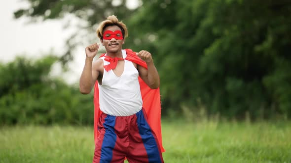 Hero man in red with crown and red mask standing and punching air