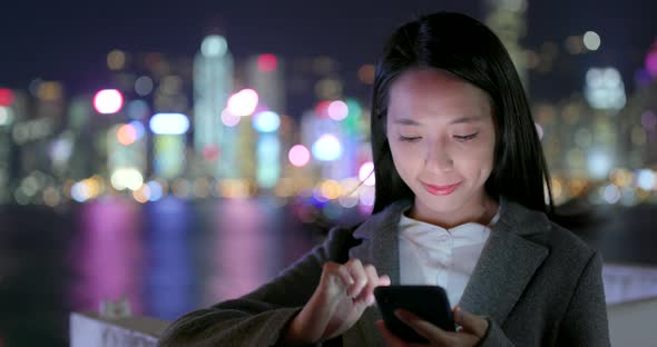 Business woman use of smart phone in city at night