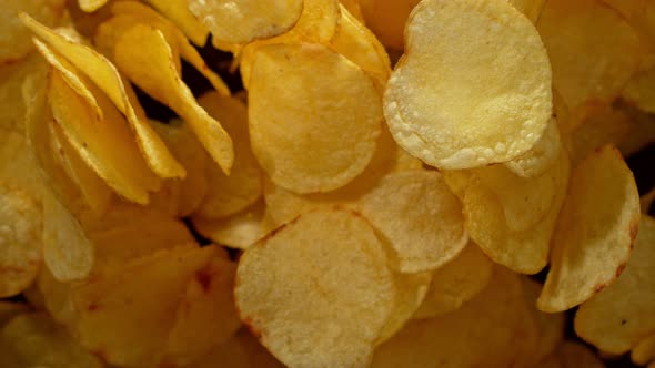 Super Slow Motion Shot of Potato Chips Flies After Being Exploded Against Black Background, 1000Fps