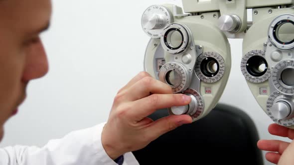 Optometrist adjusting phoropter