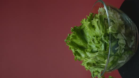 Vegetable Salad in a Rotating Glass Plate on a Burgundy Background