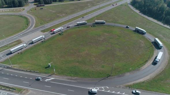 Convoy of Trucks Ride on the Highway Road Junction Near Forest Logistic Transportation View of the