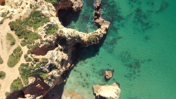 Golden cliff Escarpment opposing turquoise sea in Lagos, Algarve, Portugal