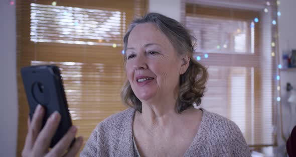 an Elderly Couple in Retirement Communicates By Video Call with Their Relatives