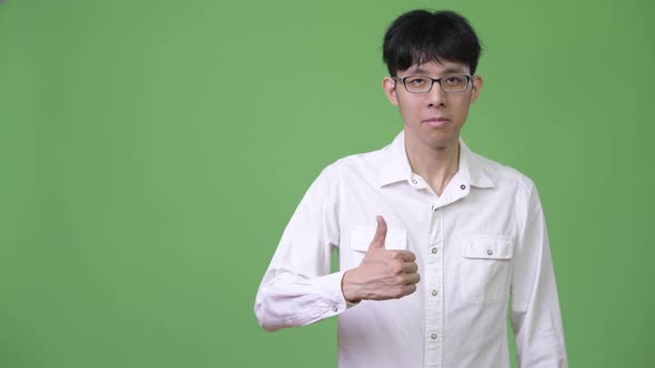 Young Asian Businessman Giving Thumbs Up