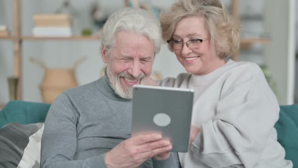 Loving Old Couple Using Tablet Together at Home