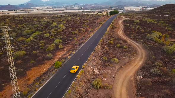 Top View of a Car Rides Along a Desert Road