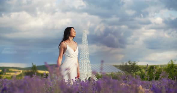 A Girl in a White Dress Walks Through a Lavender Field