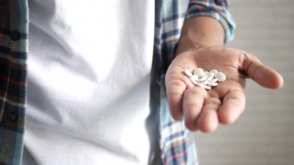 Man's Hand with Medicine Spilled Out of the Pill Container