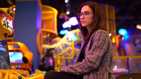 A Young Woman Is Sitting in an Amusement Park. The Camera Moves Closer To the Girl. Park for