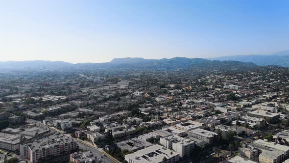 Aerial camera rises above city on a sunny day in Los Angeles, California, USA