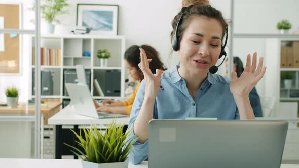 Beautiful Mixed Race Lady Speaking Using Laptop Working in Call Center with Group of Women