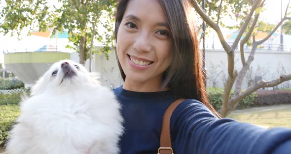 Woman with her Pomeranian dog at outdoor park