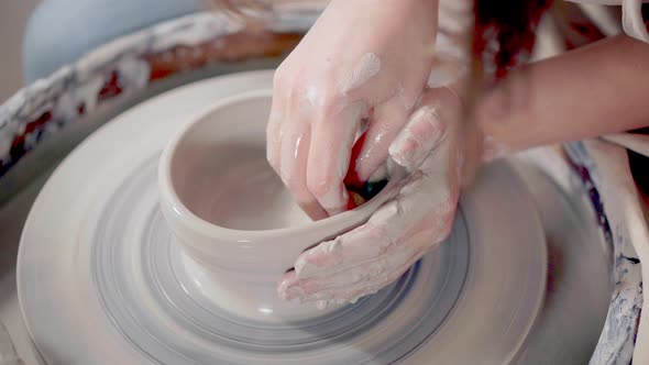 Woman Is Wetting and Softening Clay on Potter's Wheel in Pottery, Close-up
