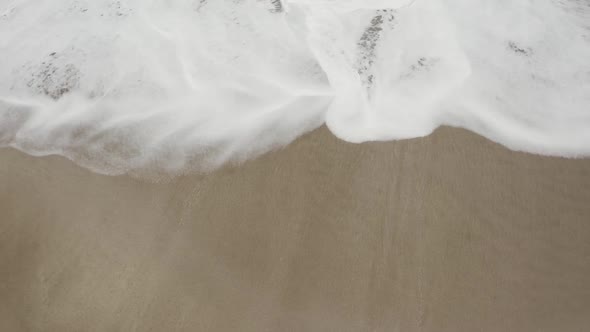 Arabian Ocean waves with foam of blue and turquoise color. Sea foam creating amazing shapes and patt