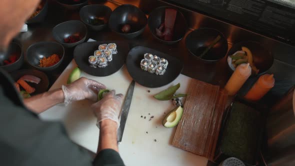 Professional Chef Rolling Rice Balls Inside Avocado Slices