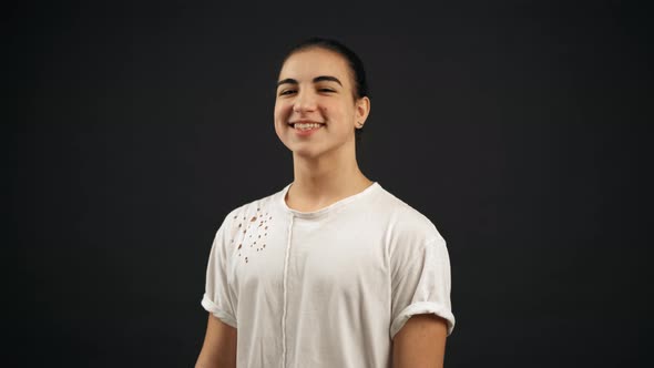 Portrait of a Happy Teenager Boy with Long Hairs. Looking at Camera and Smiling.  Slow Motion Shot