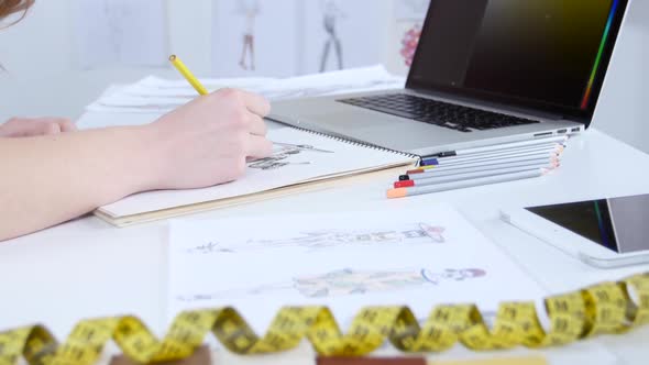 Fashion Designer Draws Sketches for a New Collection and Looks at the Computer