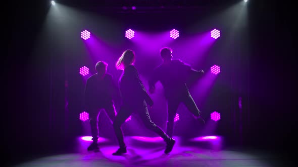 Silhouettes of a Talented Group Young Hip Hop Dancers. Hip Hop Street Dance on a Stage in Dark