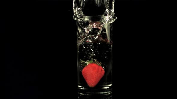 Super Slow Motion in a Glass of Water Drops Strawberries with Splashes