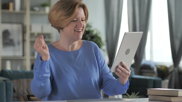 Old Senior Woman Celebrating Success while Using Tablet