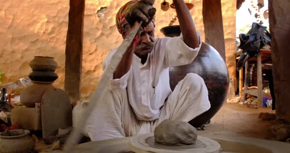 Skilled Professional Potter Throwing the Potter's Wheel and Shaping Traditional Ceramic Vessel and