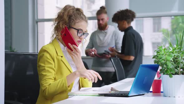 Businesswoman Talking on Phone and Writing Down Information