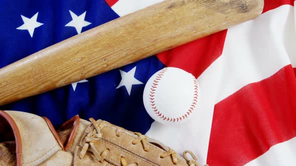 Baseball, baseball bat and baseball gloves on an American flag