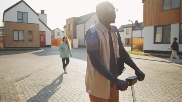 African American Man Riding E-Scooter on Street