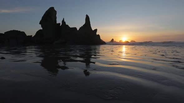 Sunset on Huge Sandy Ocean Beach Among Bizarre Stones and Rocks