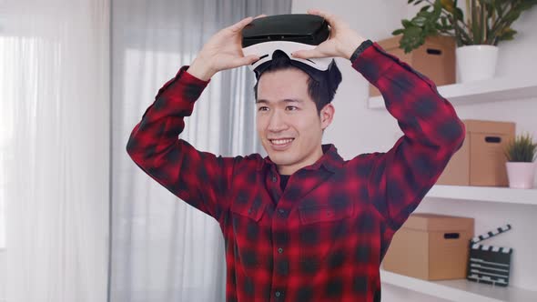 Happy Young Asian Man Removing VR Headset