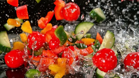 Super Slow Motion Shot of Colorful Vegetables Falling Into Water on Black Background at 1000Fps