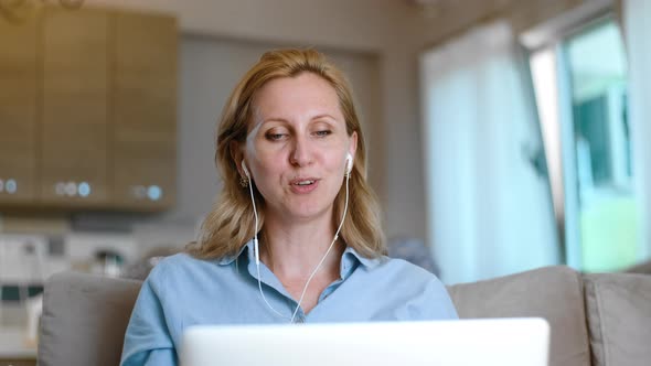 Young American Woman Talking During Video Conference and Using Laptop at Apartment Room Rbbro