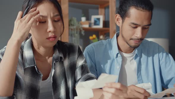 asia man and woman use calculator for calculate family budget debts monthly expenses.