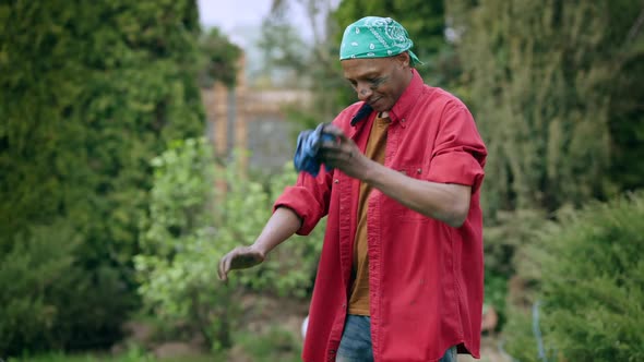 Tired African American Young Man Cleaning Dirty Hands with Cloth and Leaving