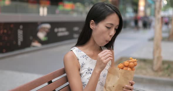 Woman eating Hong Kong famous snack, egg puff
