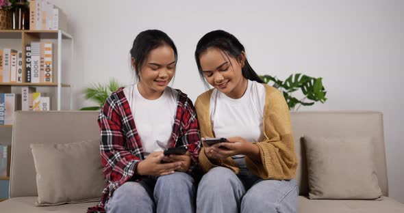 Twin girls playing game on smartphone together