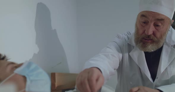 Sympathetic Doctor Holds Patient's Hand and Supports Him in Hospital