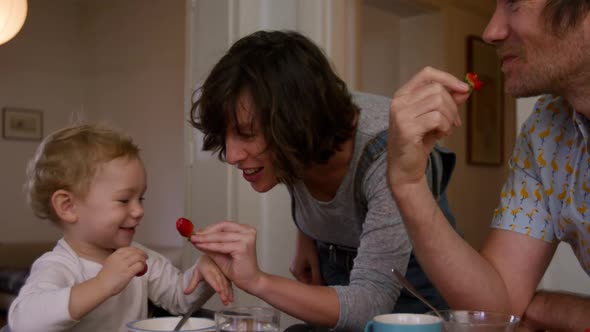 Caucasian family eating strawberries at home